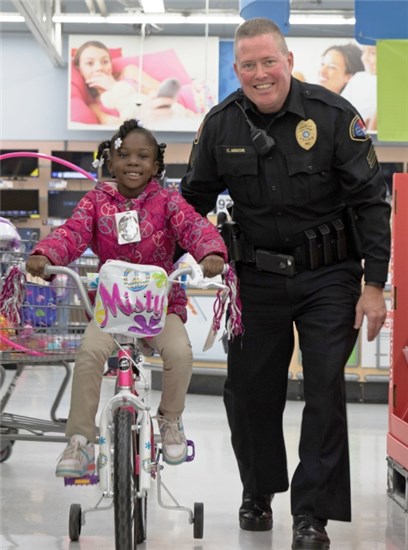 Child Riding a bike with a cop while they shop